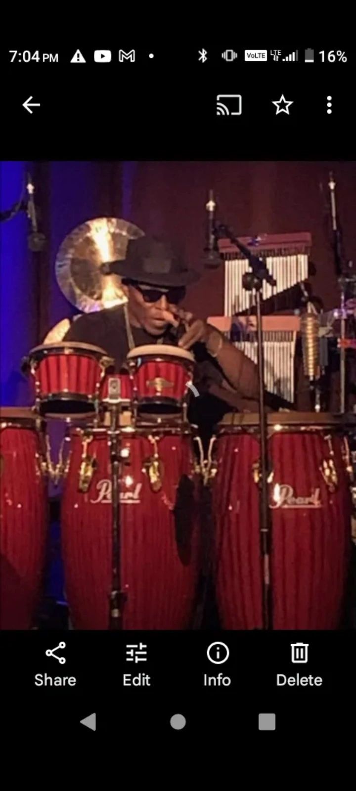 Larry Sprinkles Strickland playing congas with purple lighting