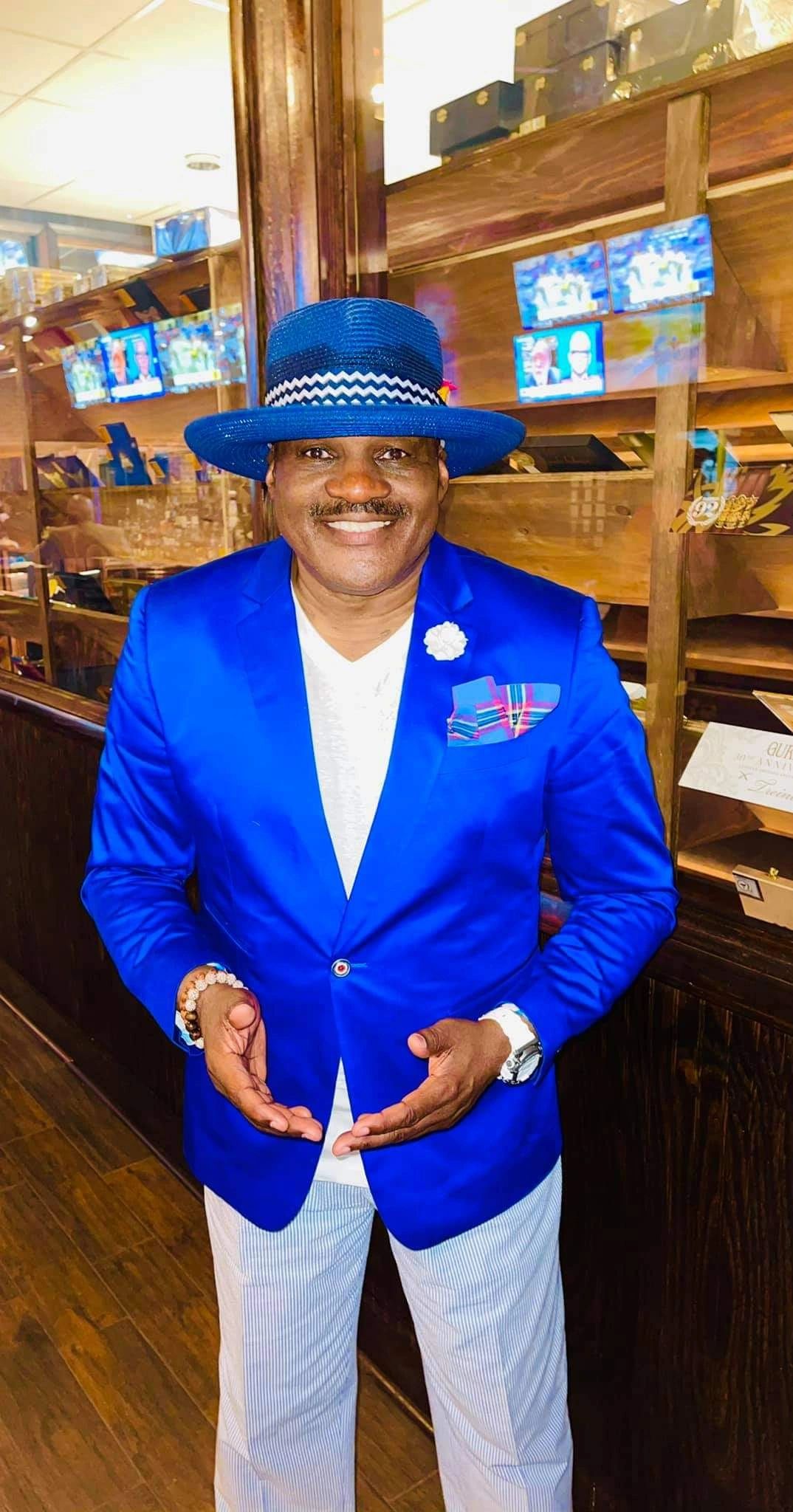 Julius Williams in bright blue blazer and blue hat portrait