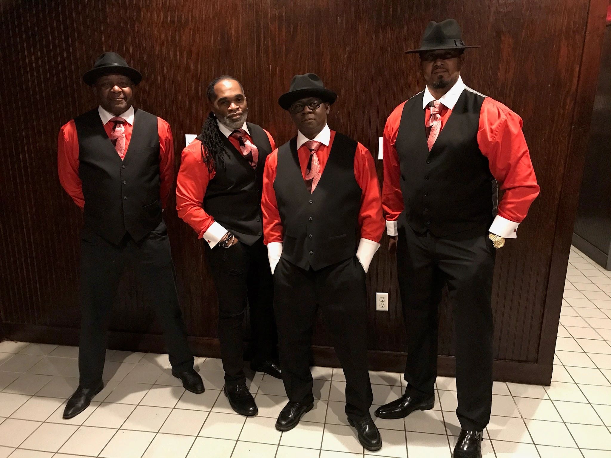 Four men in red satin shirts and black fedoras formal group photo
