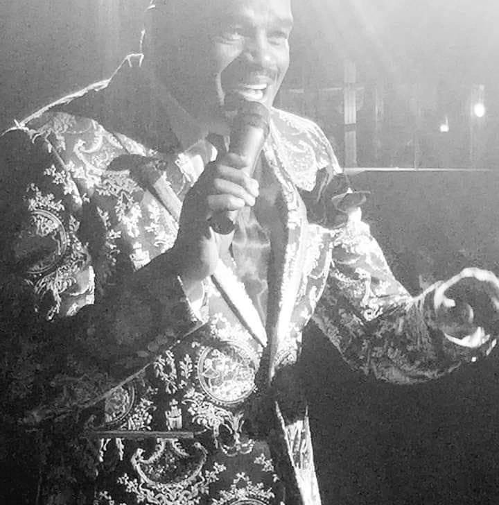 Julius Williams black and white photo in ornate suit holding microphone