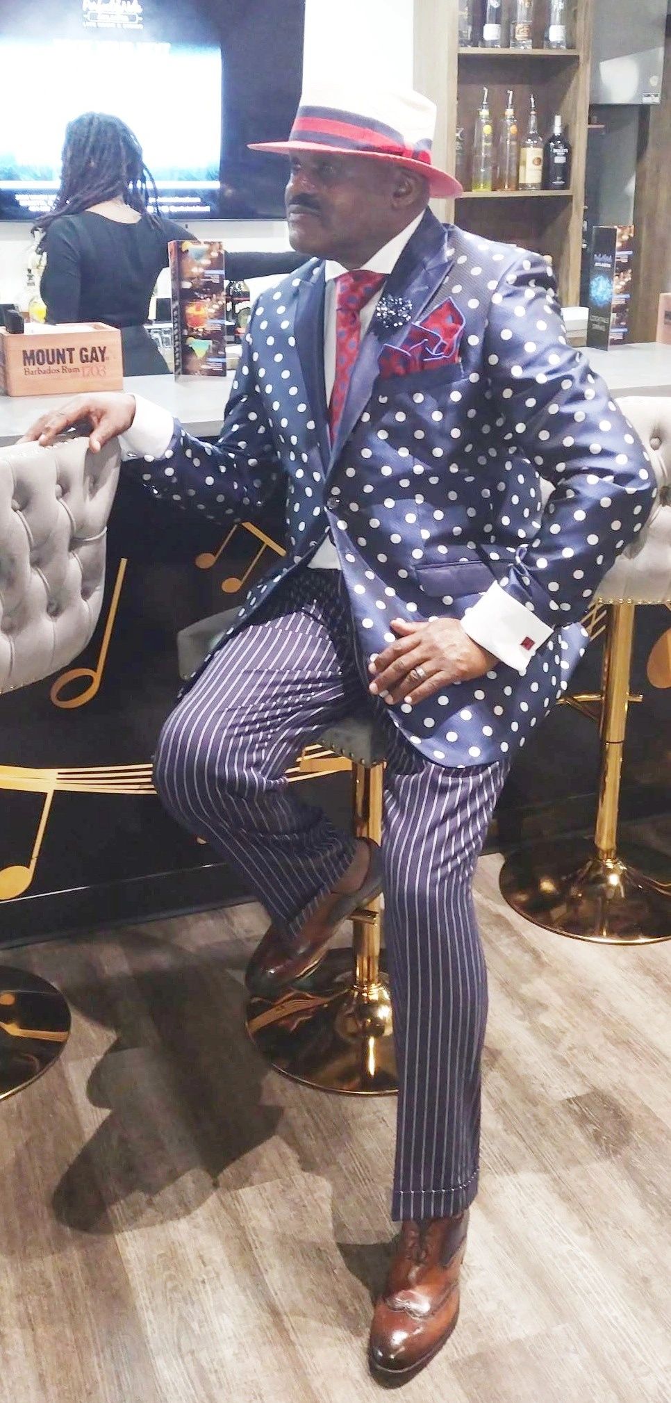Julius Williams in navy polka dot blazer and red fedora at venue
